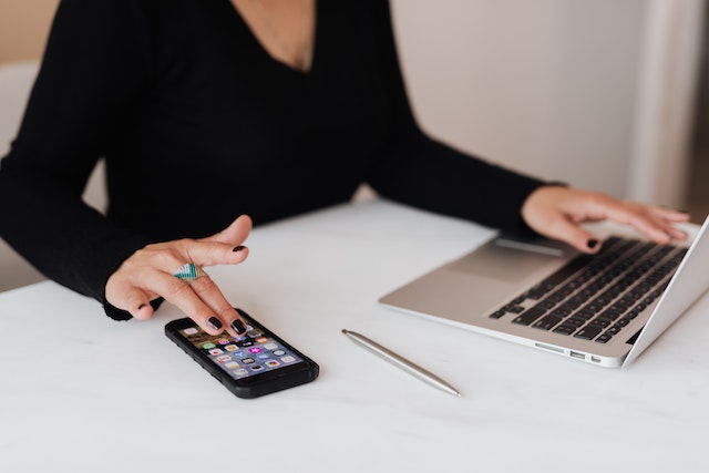 property-manager-sitting-at-desk-with-laptop-pen-and-phone