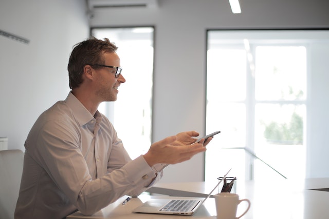 property-manager-speaking-on-phone-at-desk-with-laptop