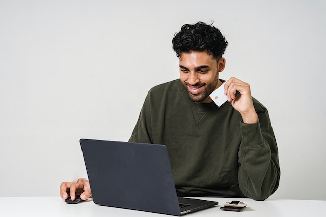 tenant-wearing-sweater-on-laptop-paying-rent-with-credit-card