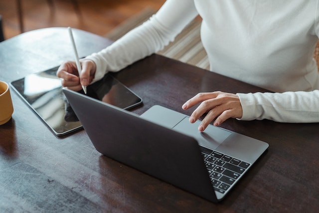 redsail-property-manager-sitting-at-desk-on-laptop-writing-notes