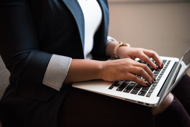 property-manager-sitting-down-typing-on-laptop