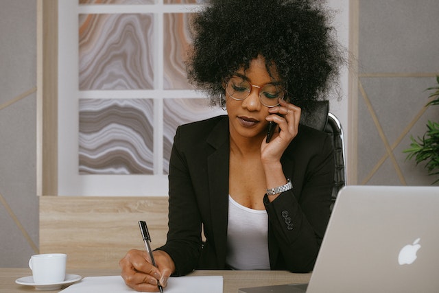 a-person-talking-on-the-phone-while-taking-notes