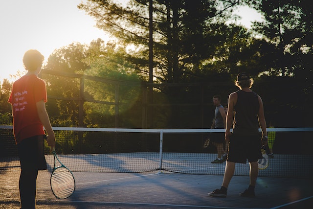 three-people-playing-tennis-outdoords