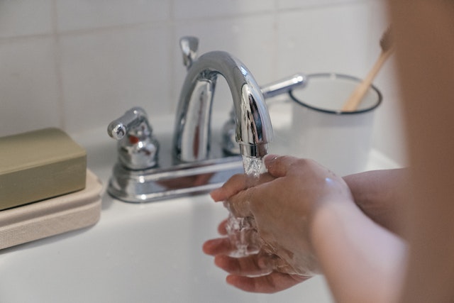 a-person-running-their-hands-under-water