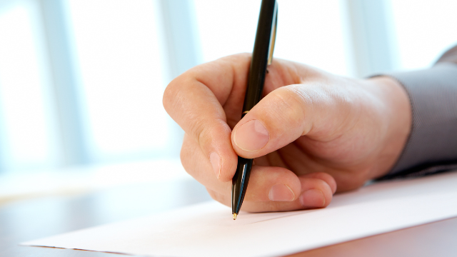 close-up-of-tenants-hand-holding-pen-writing-a-written-notice